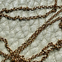 vintage 18k gold chain necklace on a textured light gray surface