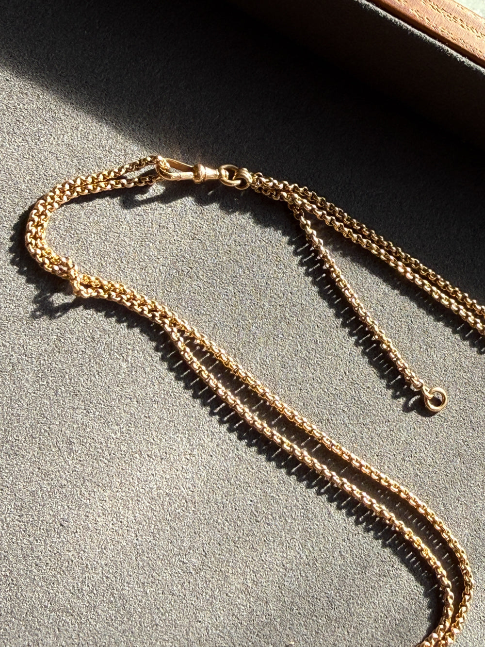Gold chain necklace on a textured surface