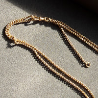 Gold chain necklace on a textured surface