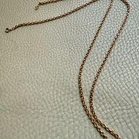 18k Gold chain necklace on a textured light green surface