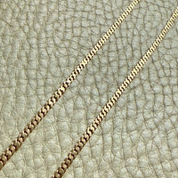 Gold chain on a textured beige leather background