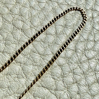 Gold chain on a textured light gray surface