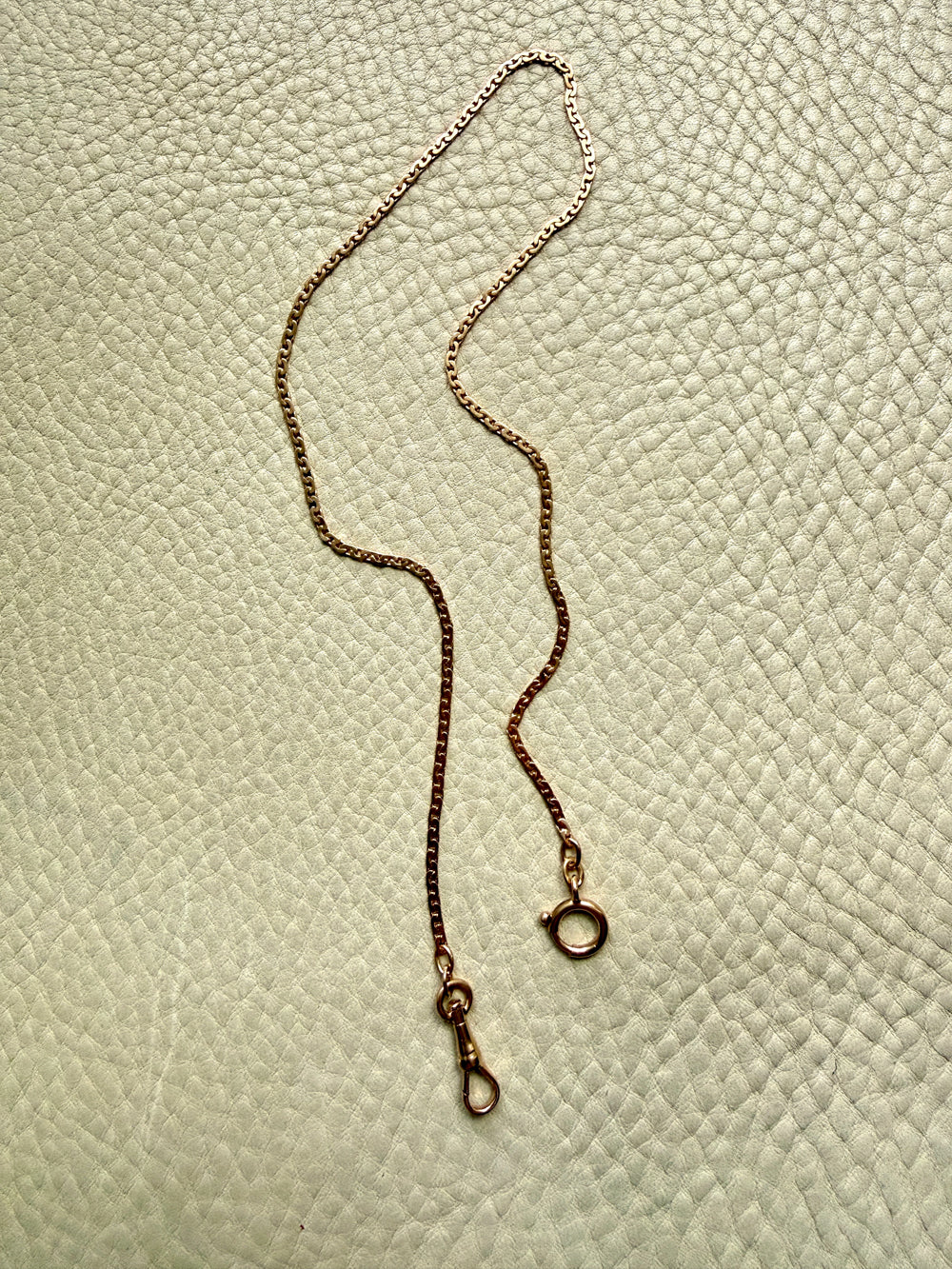 18k Gold virola link chain on a textured light gray surface
