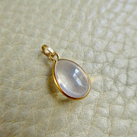 Vintage 18k Gold Teardrop Moonstone Charm - 0.75 inch drop on beige background
