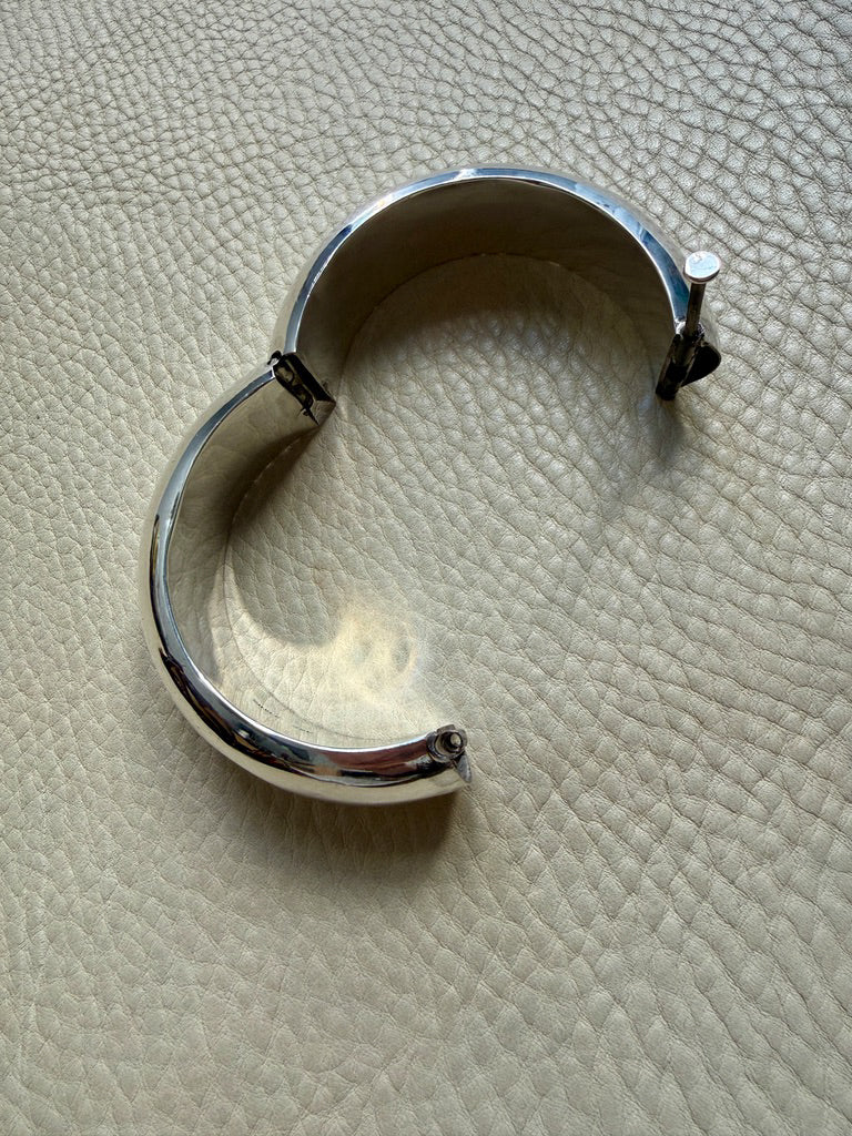 Silver bracelet on a textured beige surface