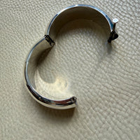 Silver bracelet on a textured beige surface