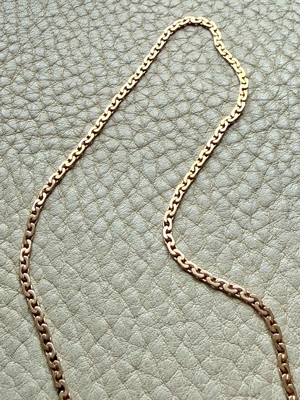 18k Gold virola link chain on a textured light gray surface