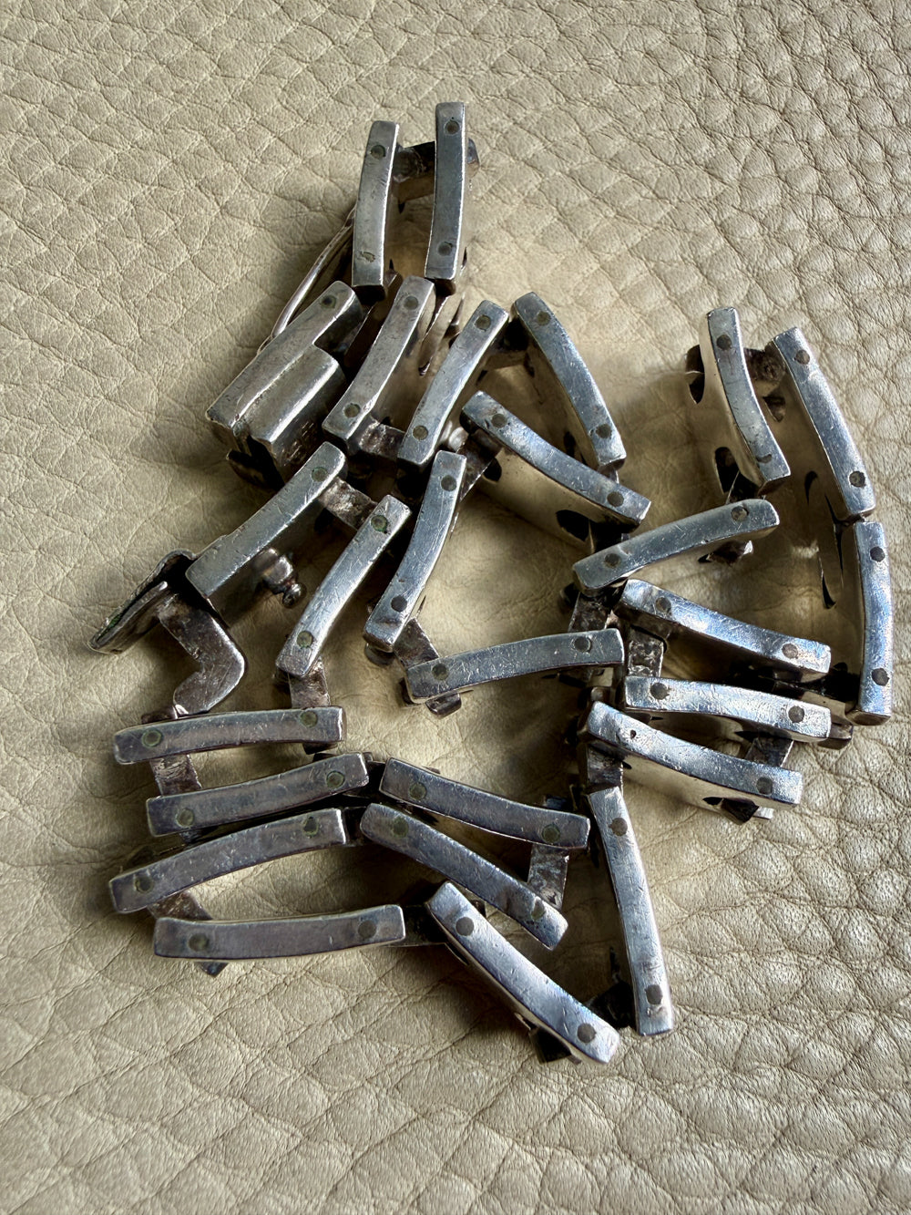 vintage silver necklace on a textured beige surface