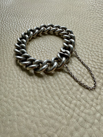 Silver chain bracelet on a textured beige surface