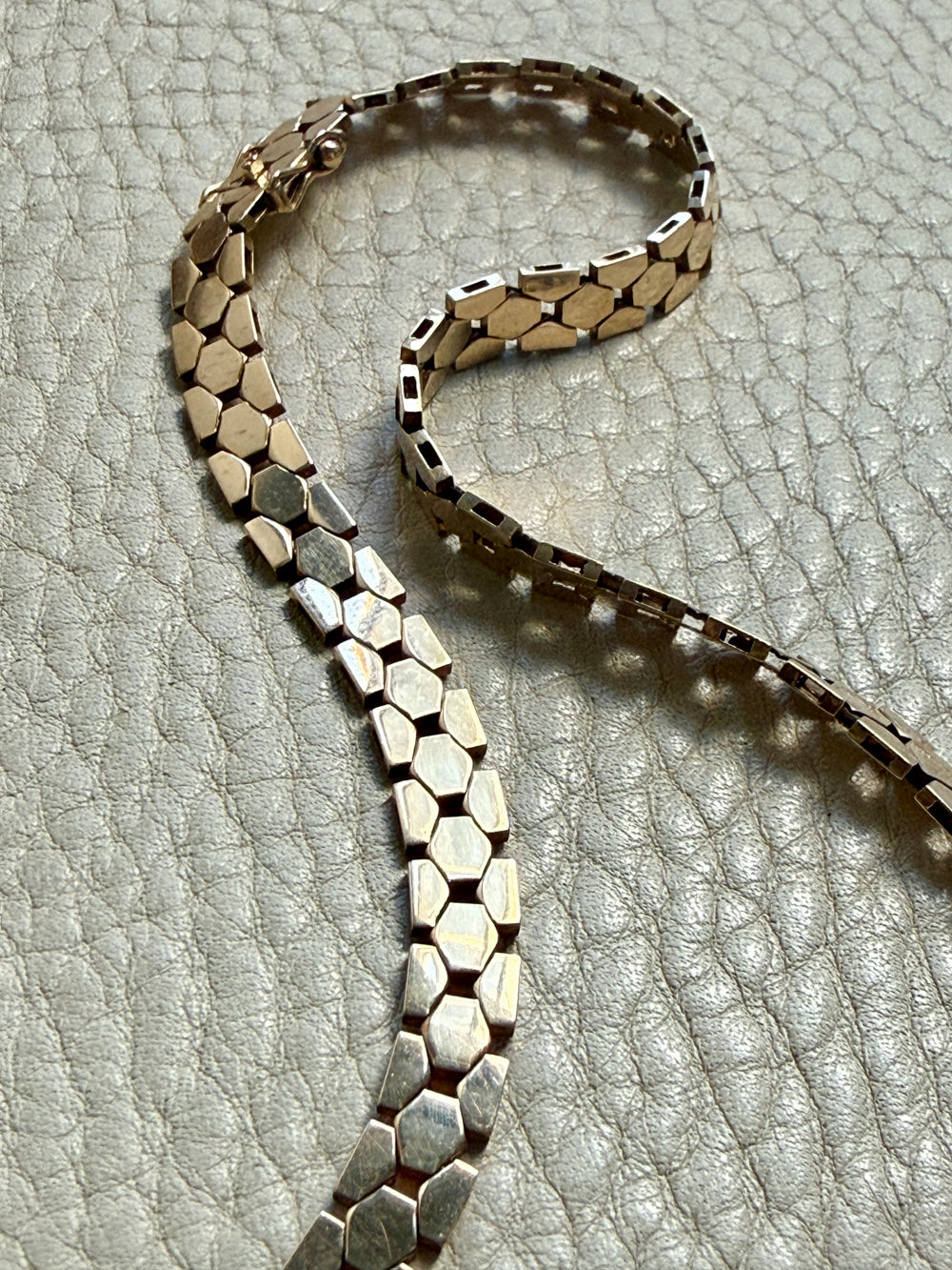 vintage 14k gold chain necklace on a textured light gray surface