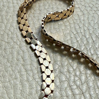 vintage 14k gold chain necklace on a textured light gray surface
