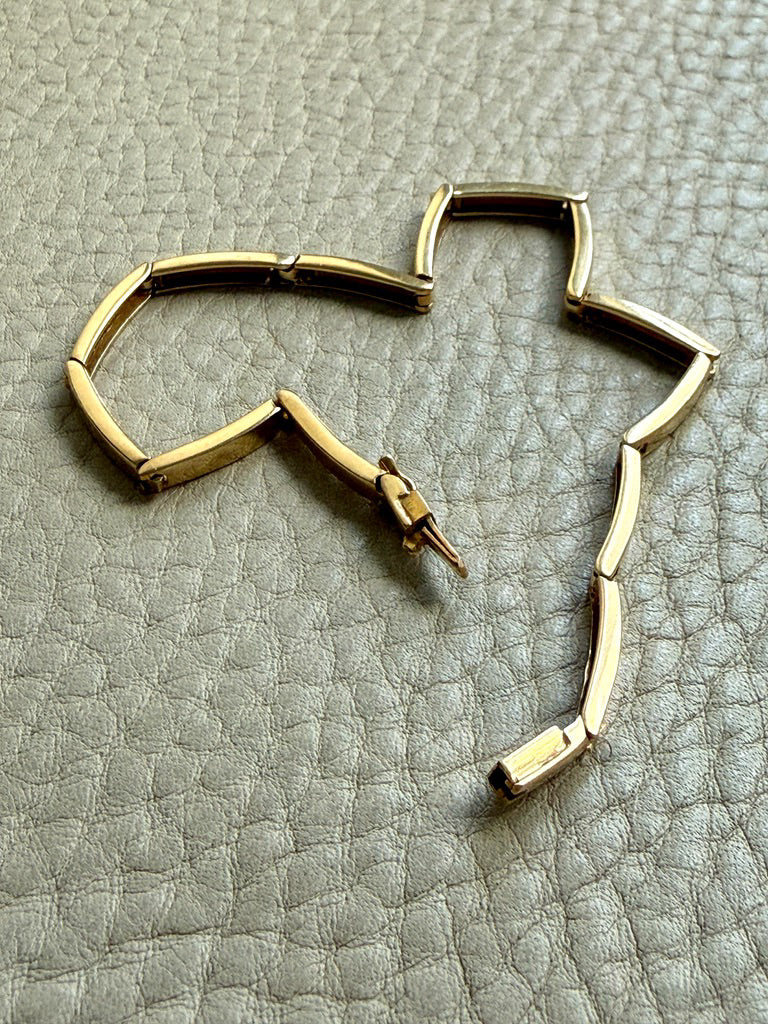 18k Gold bracelet on a textured gray surface
