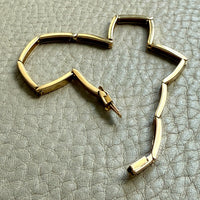18k Gold bracelet on a textured gray surface