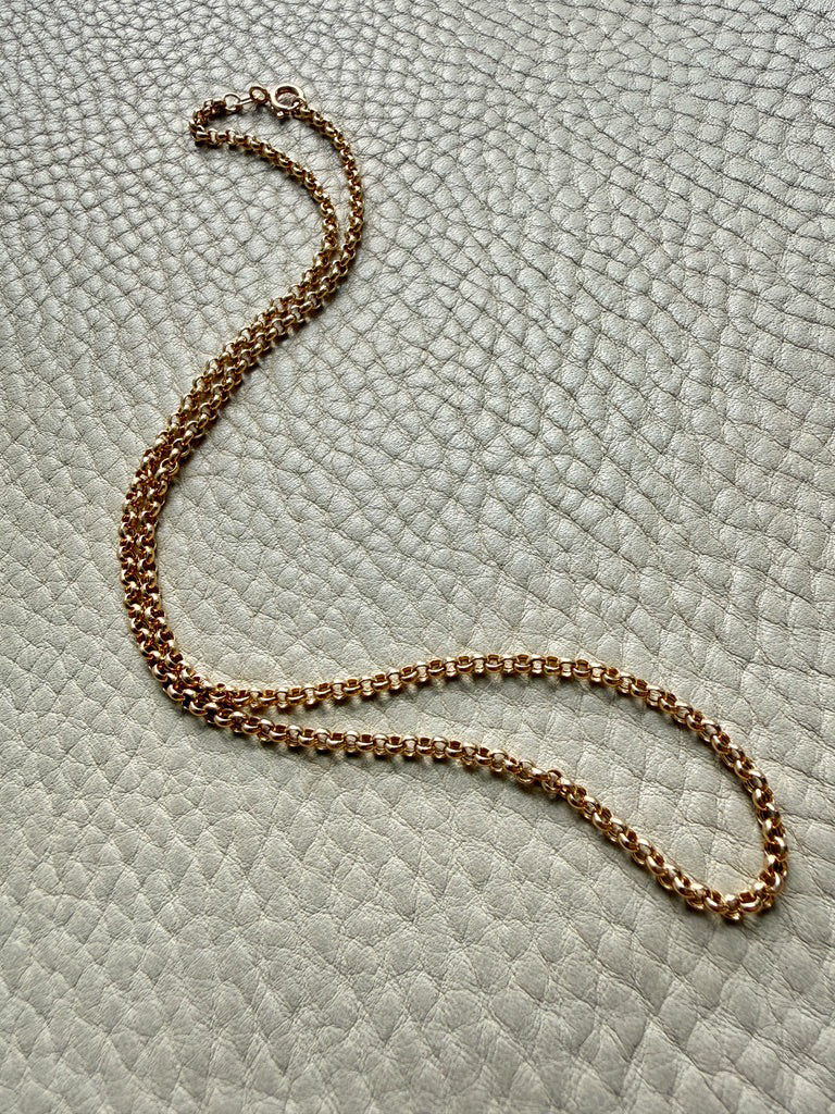 18k gold vintage rolo chain necklace on a textured light gray surface