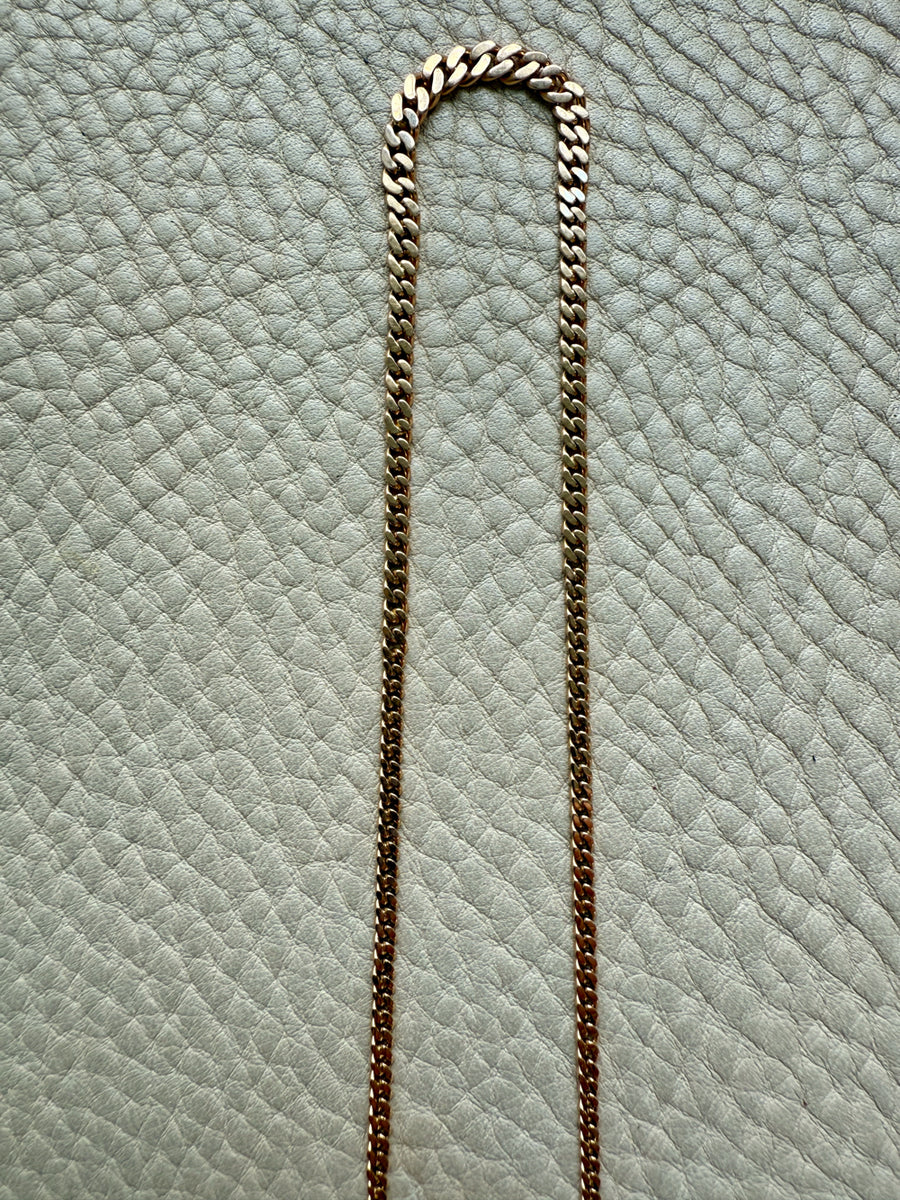 Gold chain on a textured light blue surface