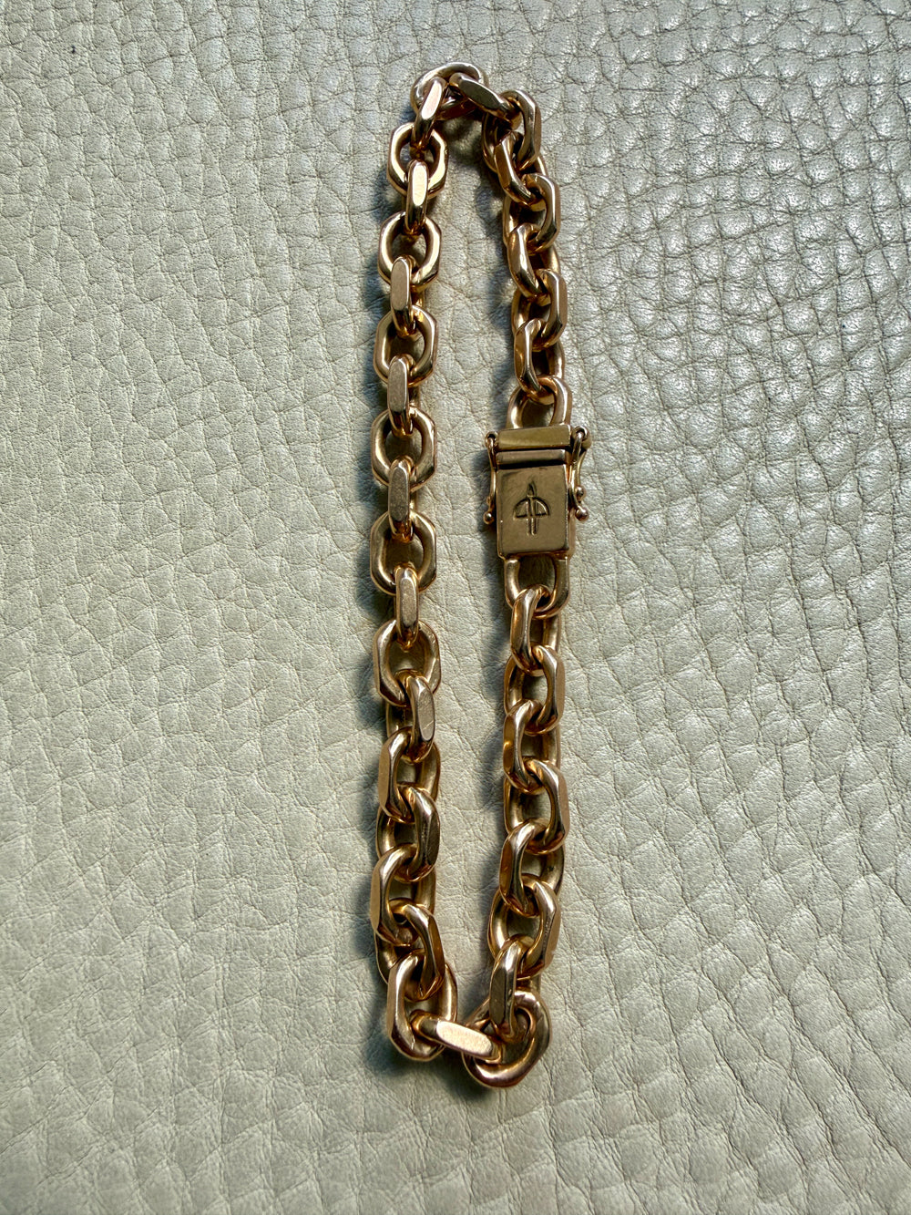 18k gold vintage biker link chain bracelet on gray textured surface 