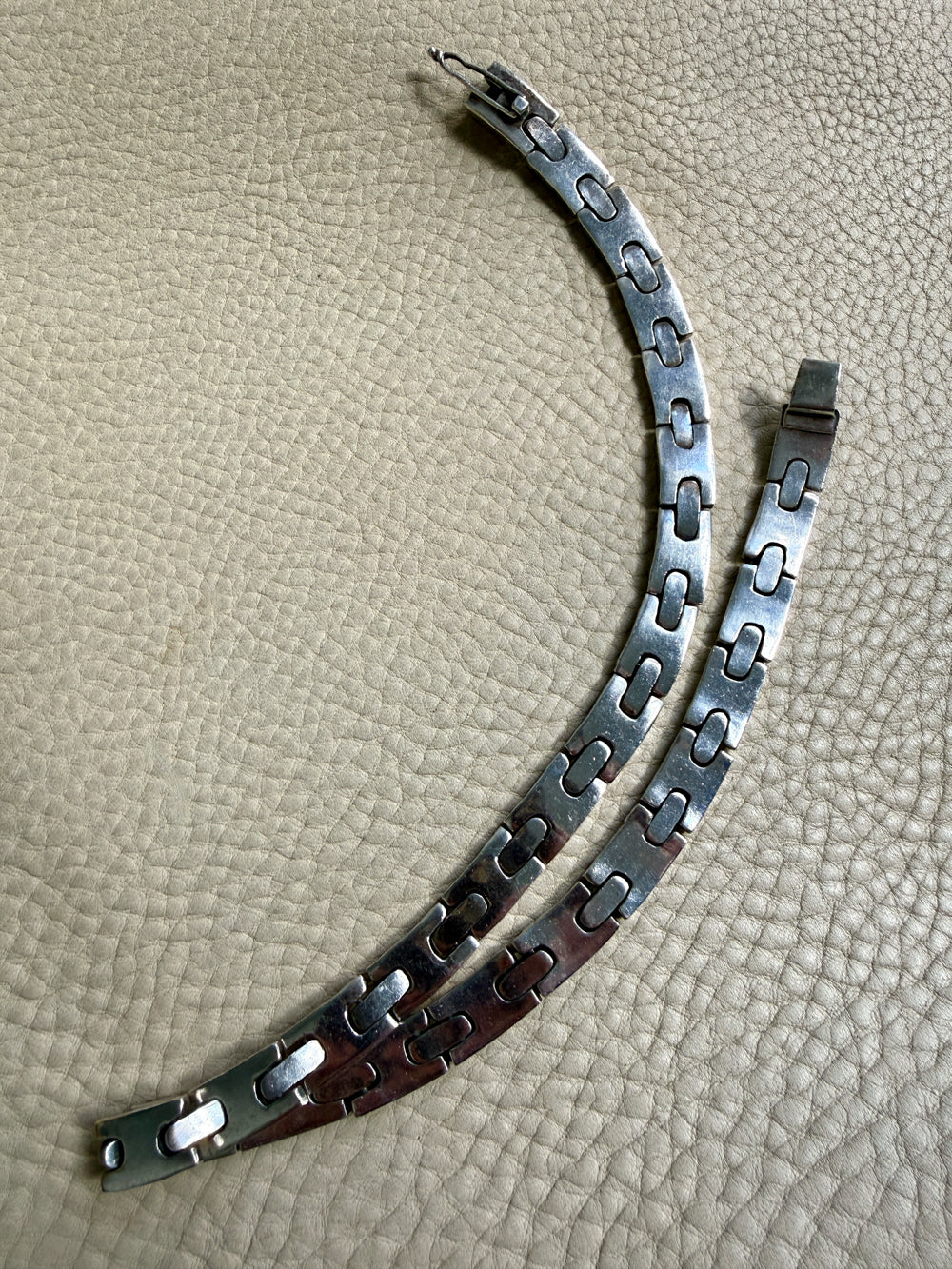 vintage silver necklace on a textured beige surface