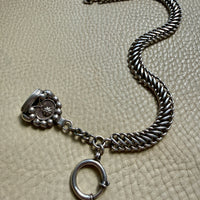 antique Silver watch chain with large bolt clasp on a textured beige surface
