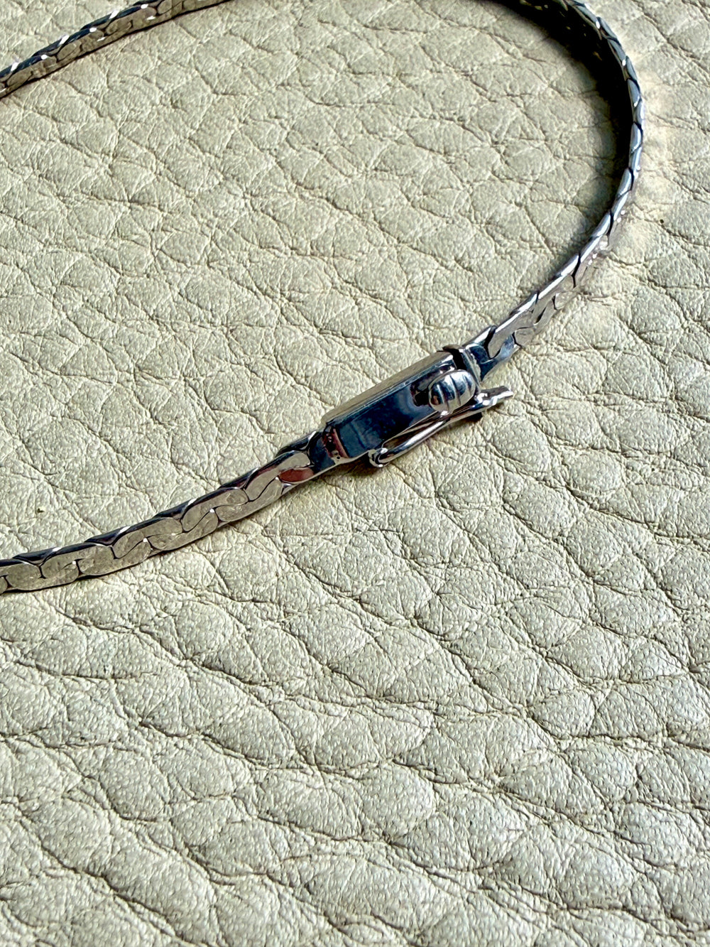 Close-up of a bracelet with a clasp on a textured surface