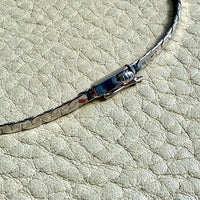 Close-up of a bracelet with a clasp on a textured surface