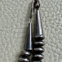 Silver necklace clasp on a textured gray surface