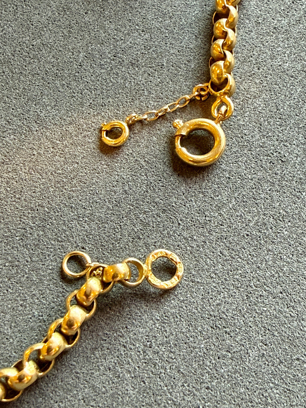 Close-up of a gold chain on a gray surface