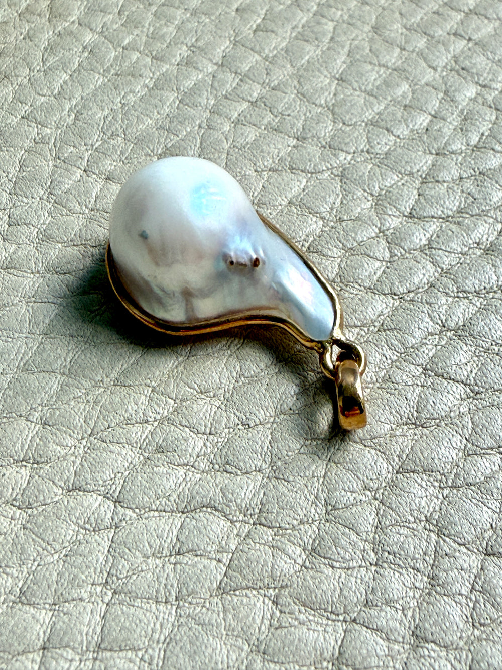 Pearl pendant on a textured gray surface