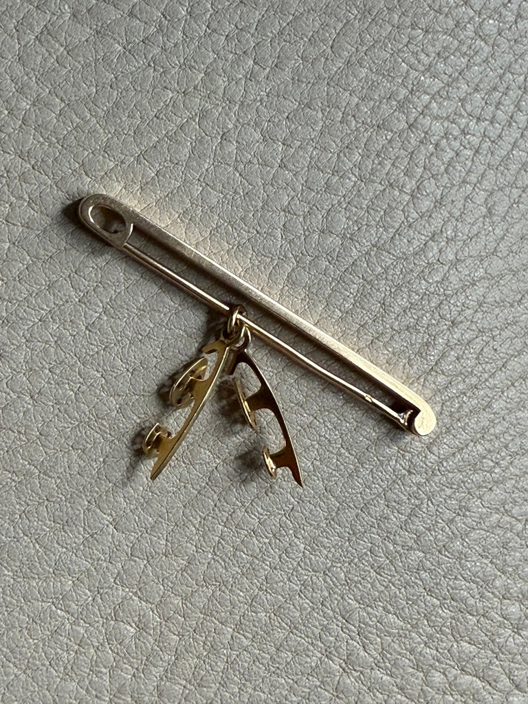 14k Gold brooch on a textured gray surface