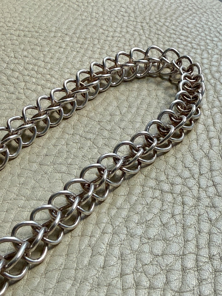 Danish vintage Silver chain necklace on a textured green surface