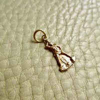 18k gold vintage charm on a beige leather surface penelopepenelope.com