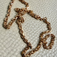 18k Gold chain biker link on a textured light gray background