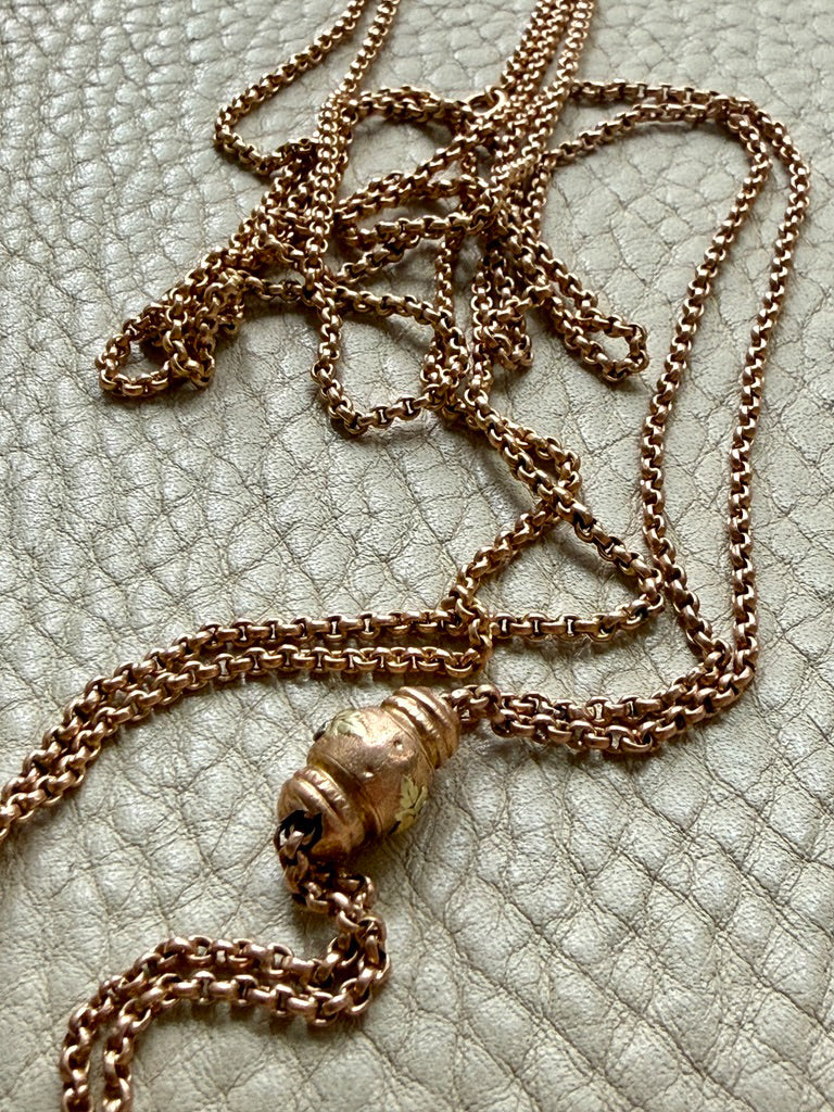 antique 18k gold chain necklace with a decorative clasp on a textured surface