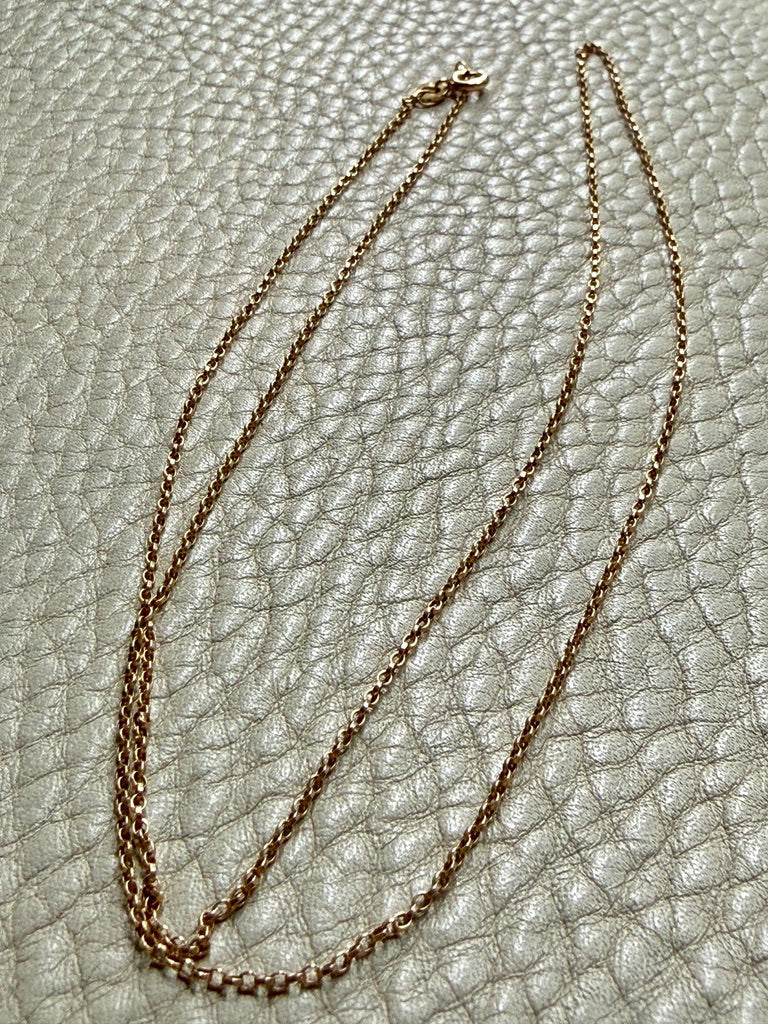 vintage 18k gold chain necklace on a textured light gray surface