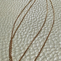 vintage 18k gold chain necklace on a textured light gray surface
