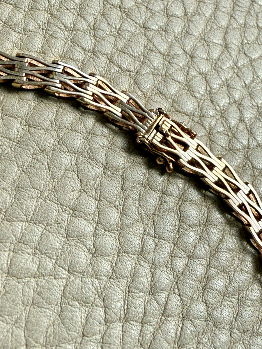 gold necklace detail on a textured gray surface