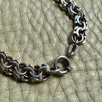 Silver chain bracelet on a textured green surface