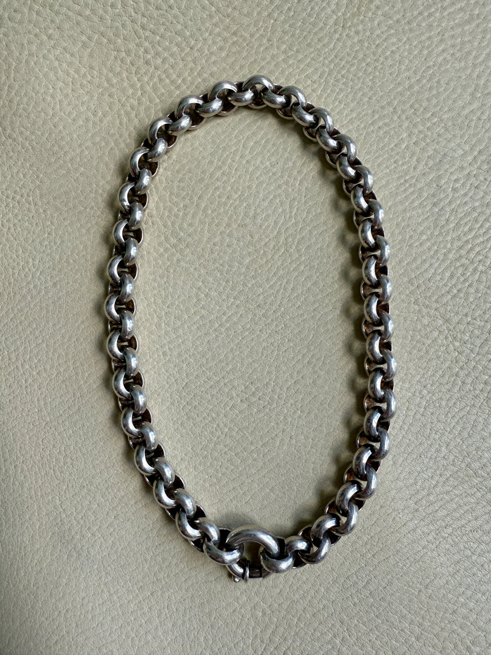 Silver chain necklace on a light gray background