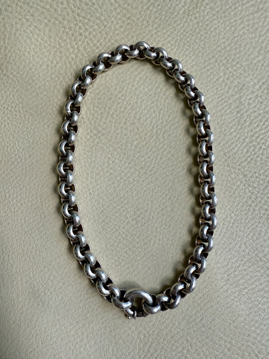 Silver chain necklace on a light gray background
