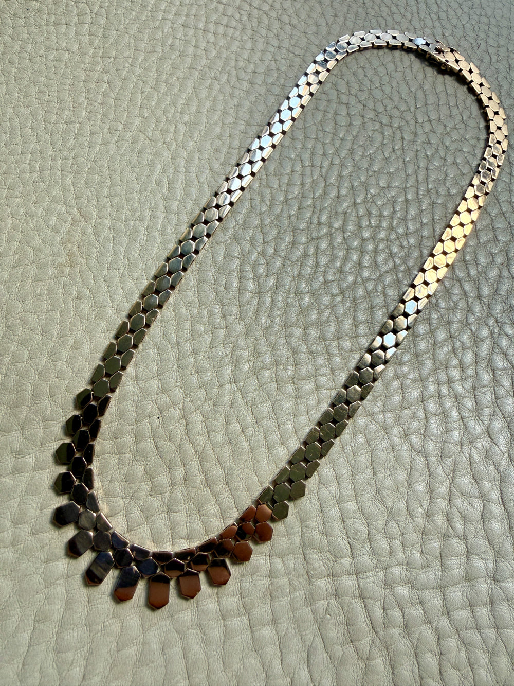 vintage 14k gold chain necklace on with hexagonal links on a textured surface