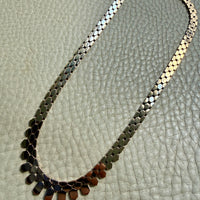 vintage 14k gold chain necklace on with hexagonal links on a textured surface
