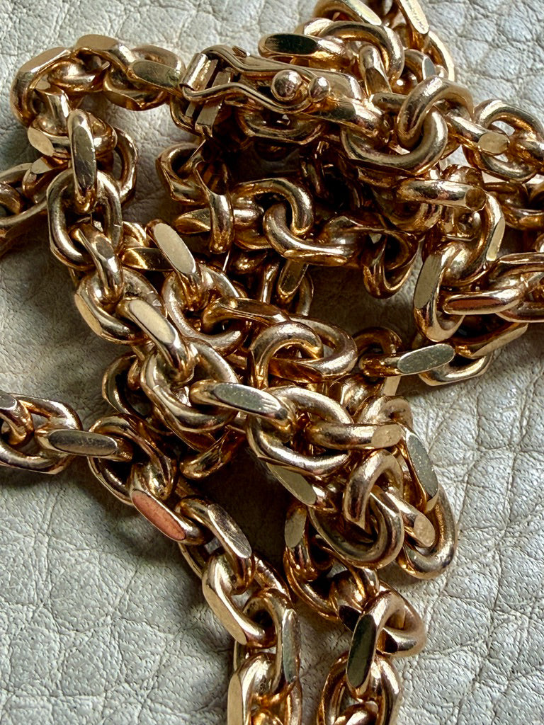 Close-up of a gold chain on a textured surface