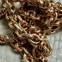 Close-up of a gold chain on a textured surface