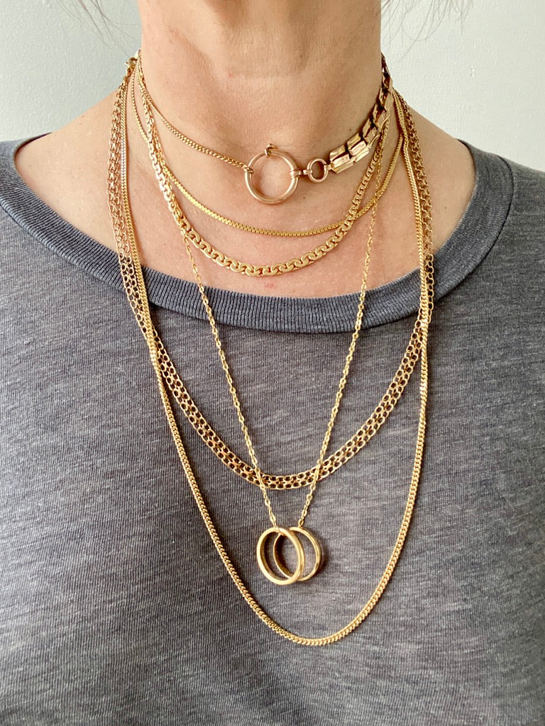 Stack of solid gold vintage chains on the neck