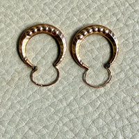 Pair of French vintage 18k Gold hoop earrings on a textured light gray surface