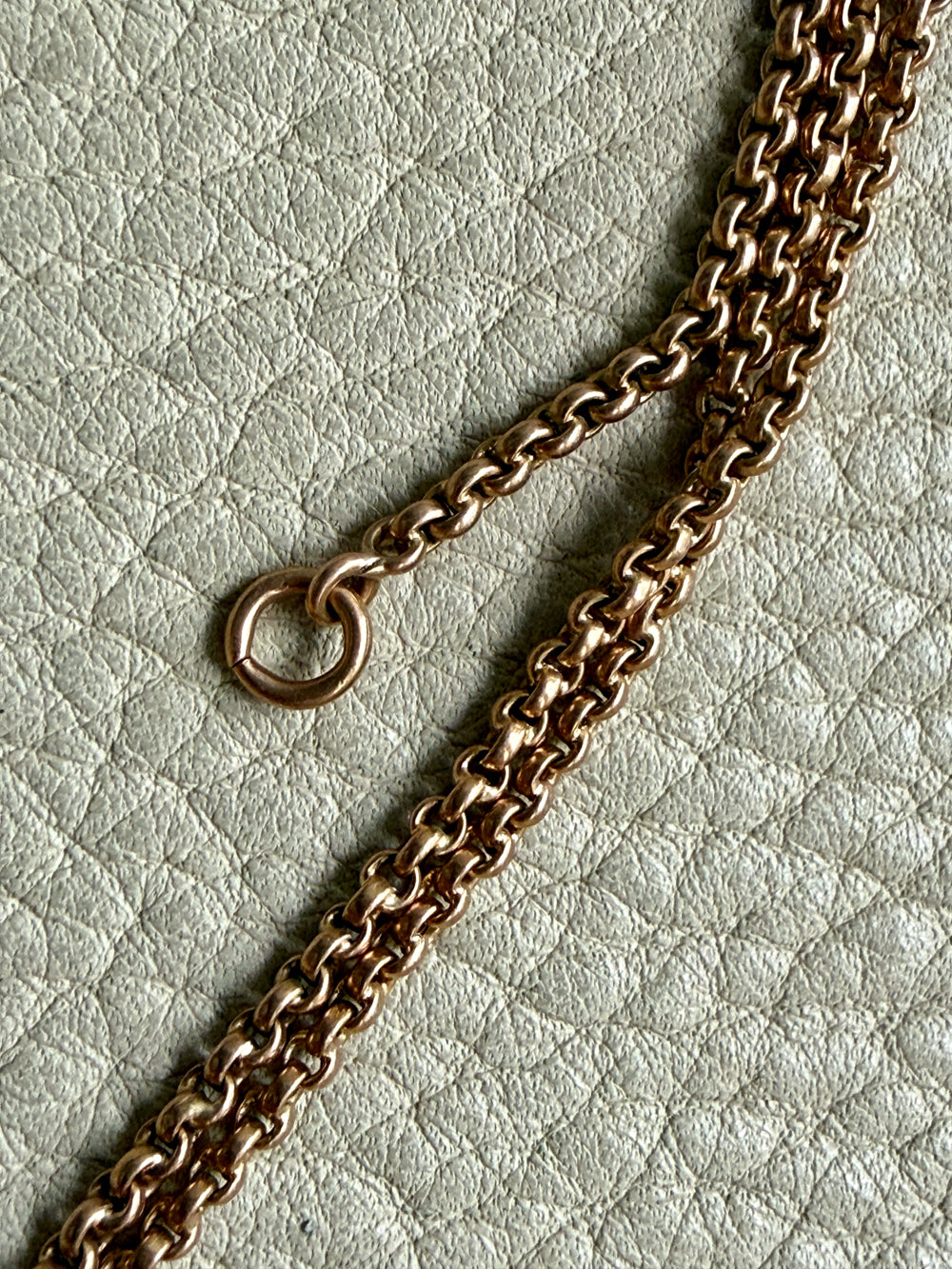 Gold chain on a textured light gray background