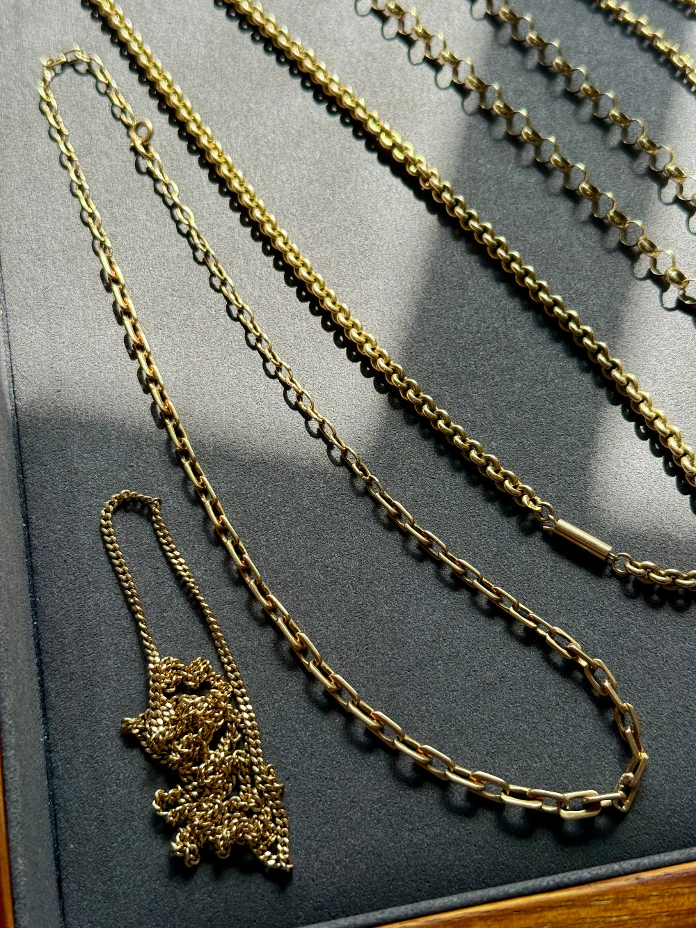 Gold chain necklace on a dark surface