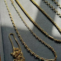 Gold chain necklace on a dark surface