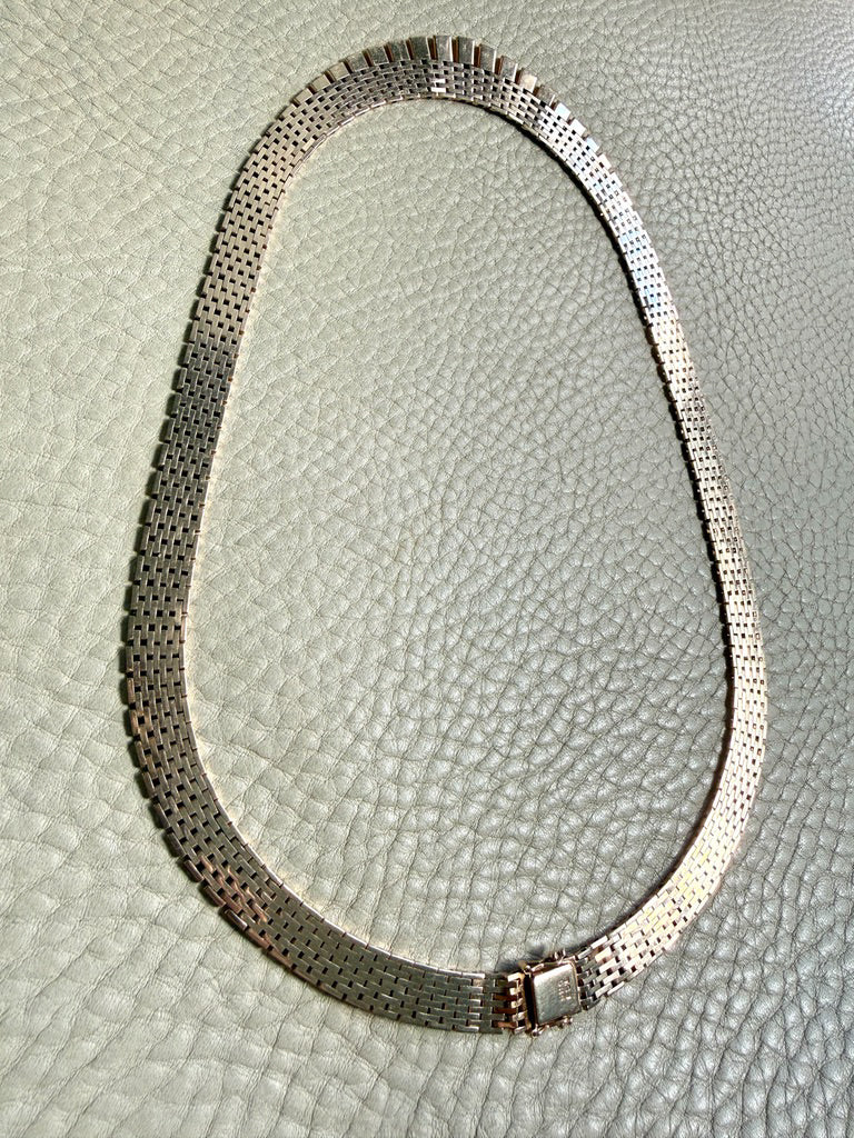 14k gold vintage cleopatra necklace on a textured light gray background