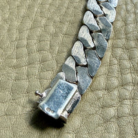 Silver chain bracelet on a textured beige surface