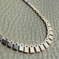 Vintage cleopatra 14k gold Necklace with square links on a textured surface
